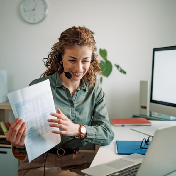 Smiling woman talking with customer online.
