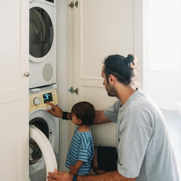 Father and son use Energy Star high-efficiency clothes dryer.