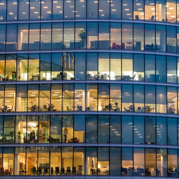 Facade of office building covered in floor to ceiling windows