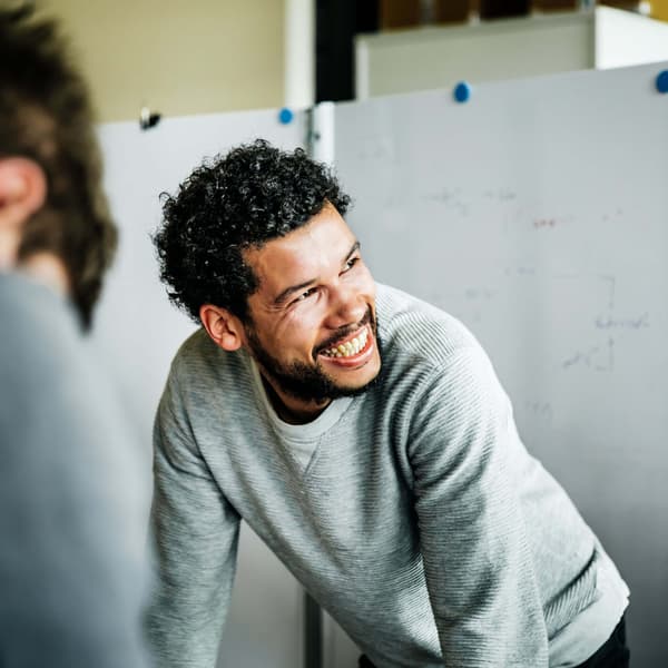 Happy employee collaborating in team meeting with his colleagues.
