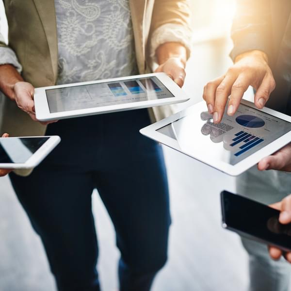 Circle of business people using energy software on their tablets.