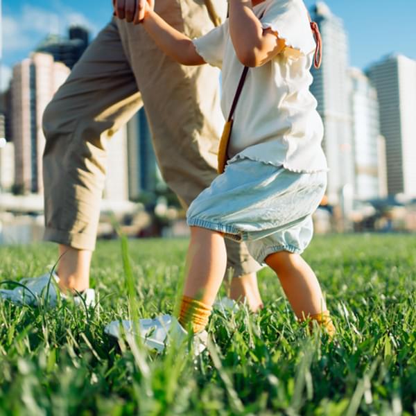 Mom and toddler walking in the park and holding hands
