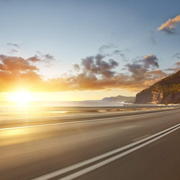 Motion blurred coastal road and mountains at sunrise