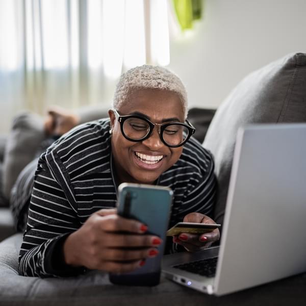 Happy person online shopping on couch