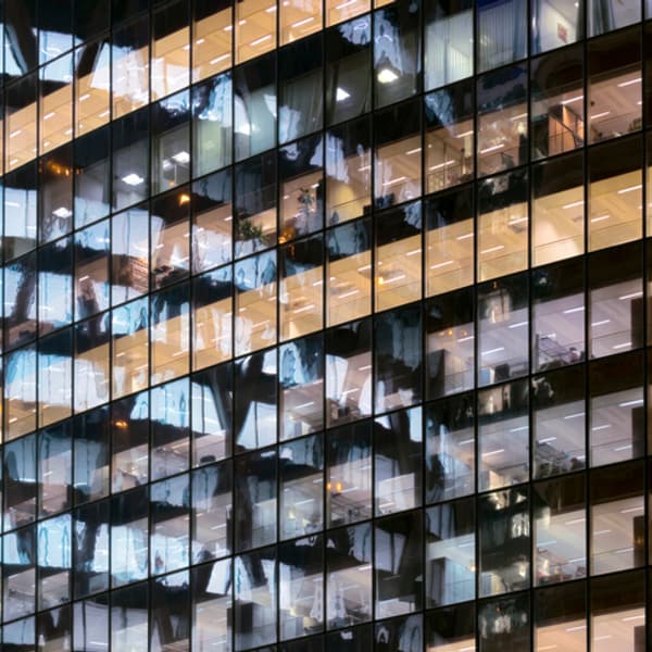 Reflections in glass office façade at dusk.