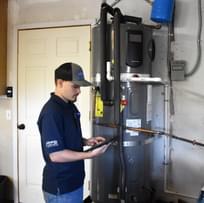 Male technician installing a heat pump water heater (HPWH)