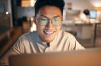 Asian male working at his laptop in office
