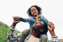 A toddler sits on dad's shoulders
