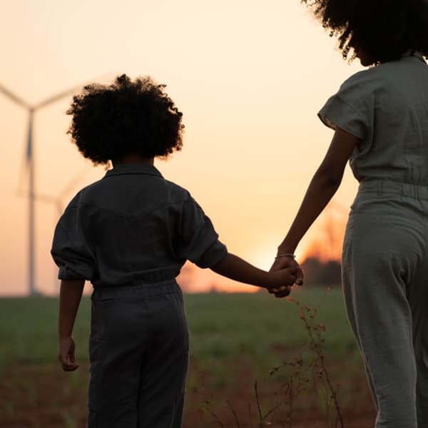 Parents take their children to visit and admire renewable energy windmills.The green technology industry produces fuel and energy from wind energy.