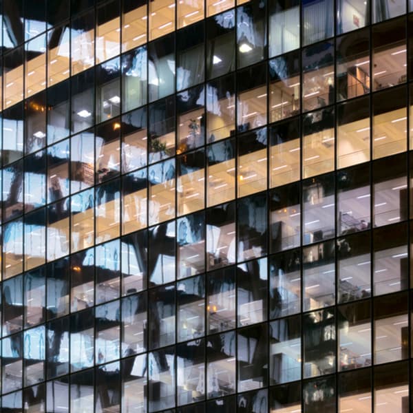 Reflections in glass office facade at dusk.