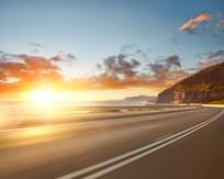 Motion blurred coastal road and mountains at sunrise