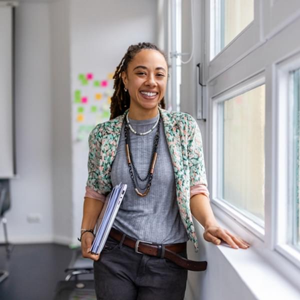 Happy African American woman working at a creative office and thinking of ideas for a project