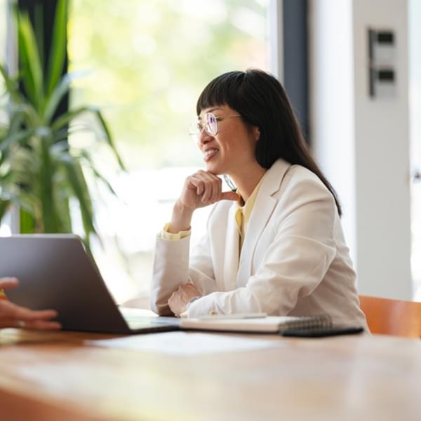Professional Asian employee in discussion at work with a coworker
