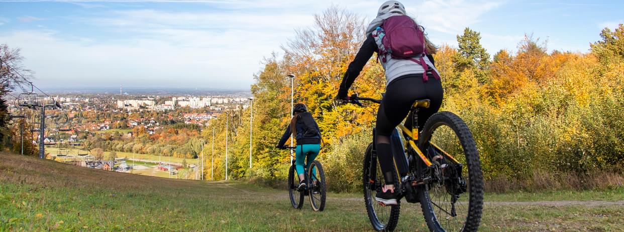 Photo of two cheerful young women on an electric bike (EV) ride on a beautiful autumn day