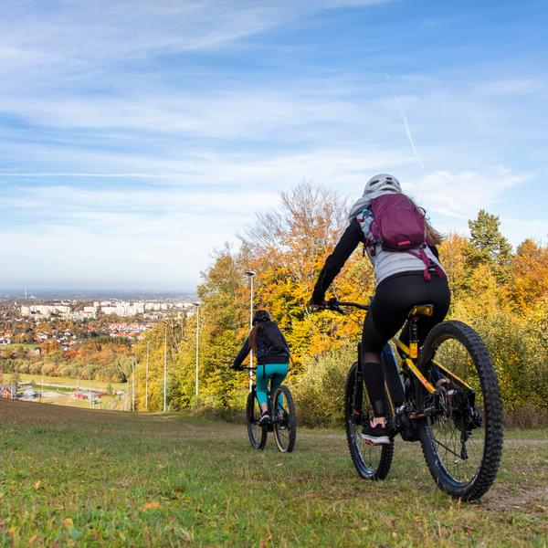 Photo of two cheerful young women on an electric bike (EV) ride on a beautiful autumn day