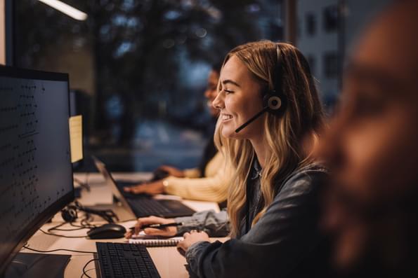 Happy female customer service professional supporting client on the phone