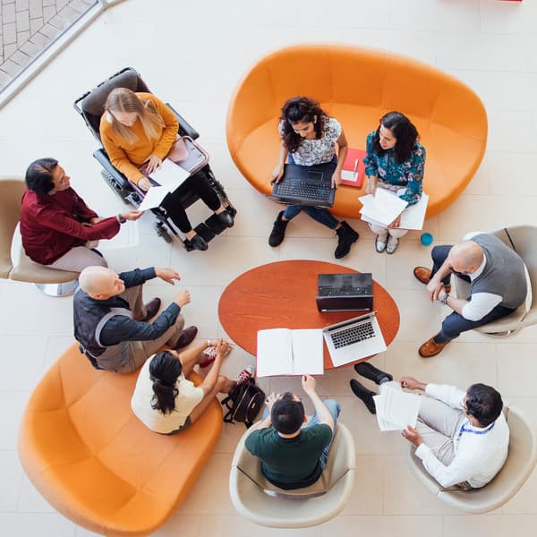 Aerial view of team of professionals in meeting around a conference table