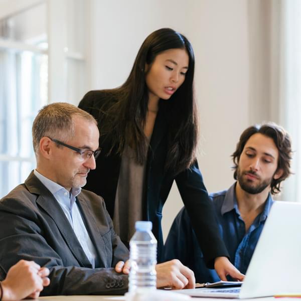Three businesspeople discussing work in a meeting