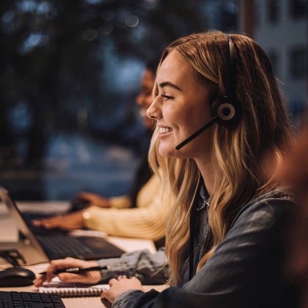 young woman customer service representative wearing a headset and speaking to a customer