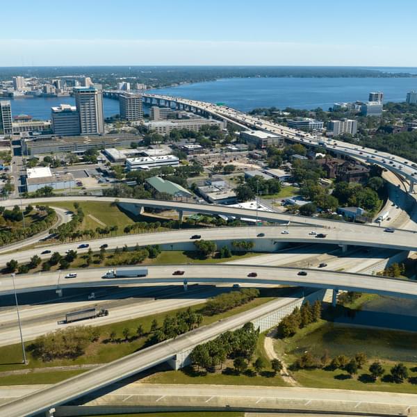 aerial view of a busy freeway interchange with roads crossing over each other and cars zooming by