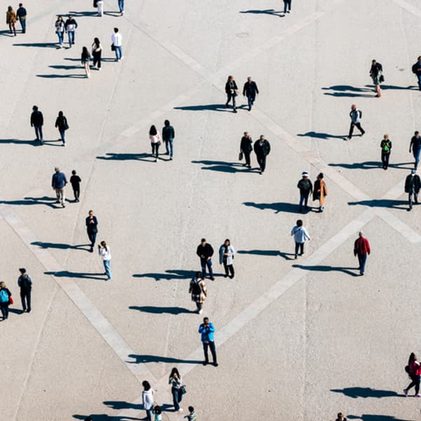 aerial view of a crowd of people walking in a town square