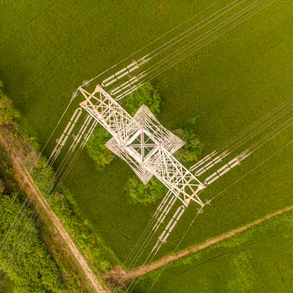 aerial view of powerlines with a green field below