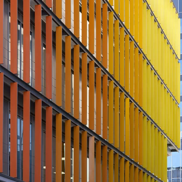 bright orange and yellow panels on the side of a tall modern office building