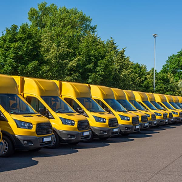 a long row of yellow electric utility vehicles neatly lined up