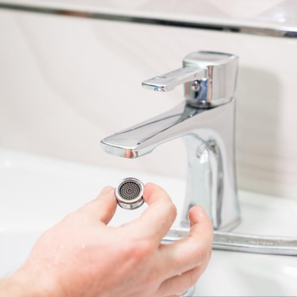 close up of hands working to replace a sink faucet in the bathroom