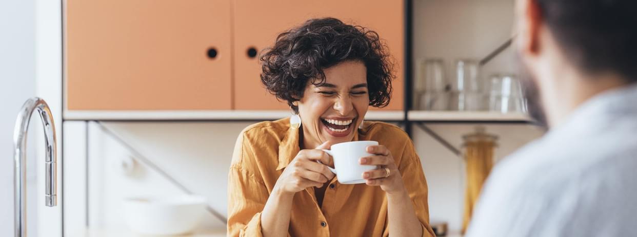 smiling woman  drinking tea in the kitchen of her home