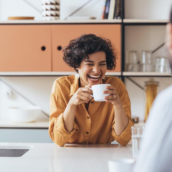 smiling woman  drinking tea in the kitchen of her home