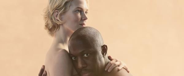 A man and woman of two different ethnicities embracing.