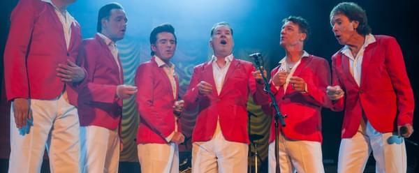 A group of singers around one microphone