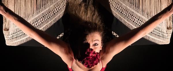 The camera looks down on a masked flamenco dancer