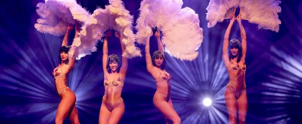 Four semi-naked burlesque dancers perform on stage