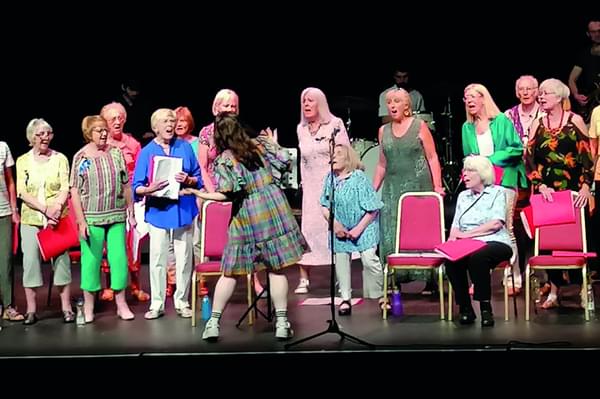 A wide angled view of The Roses' choir on stage