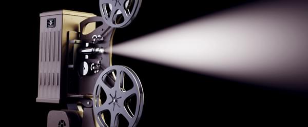 A vintage film projector against a dark background