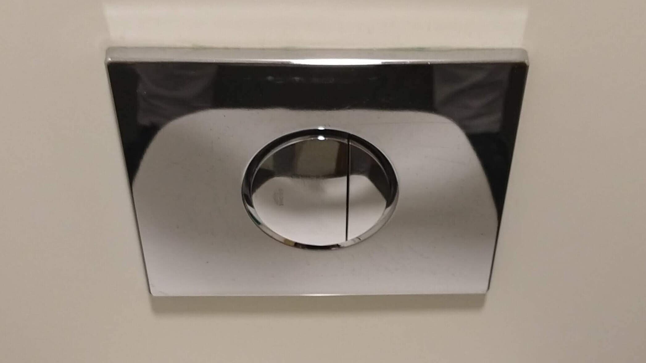 A close-up shot of dual flush toilet buttons