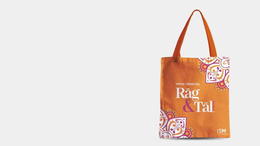 Mockup of orange tote bag with Rag and Tal logo on the front.