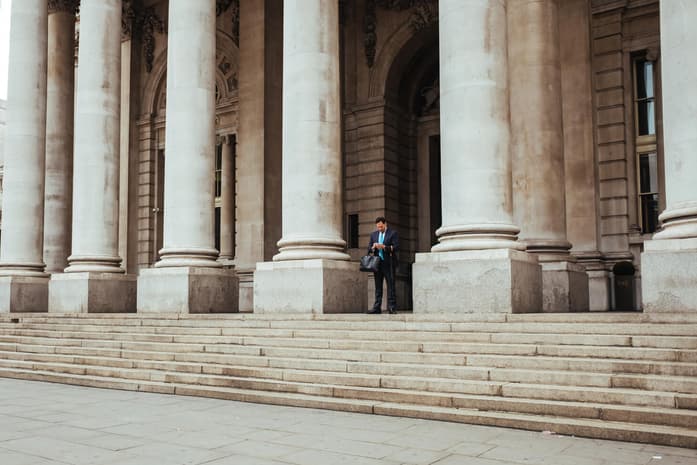 Business man standing by pillars