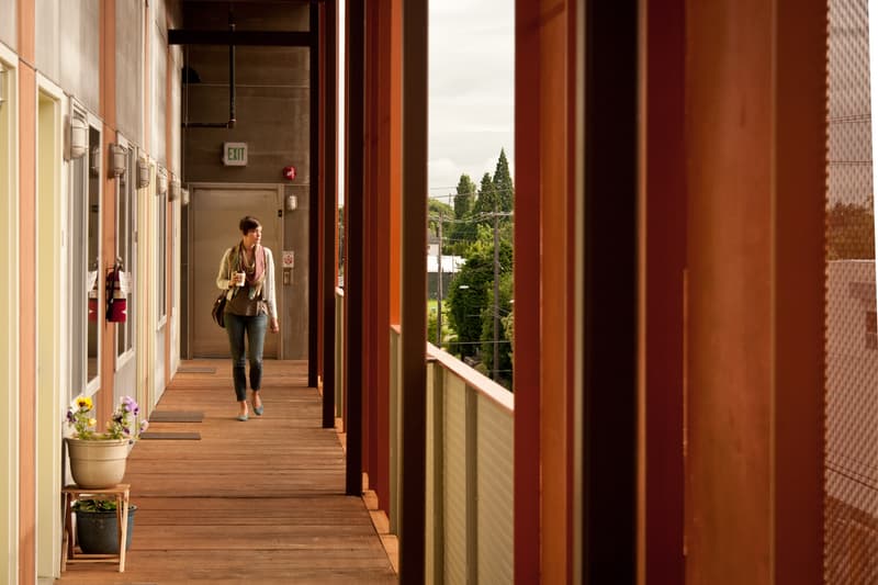 A person walking in an outdoor walkway of a building