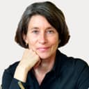 Eine braunhaarige Frau lehnt sich auf ihre Faust