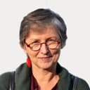 Eine grauhaarige Frau mit dunkelroter Nickelbrille