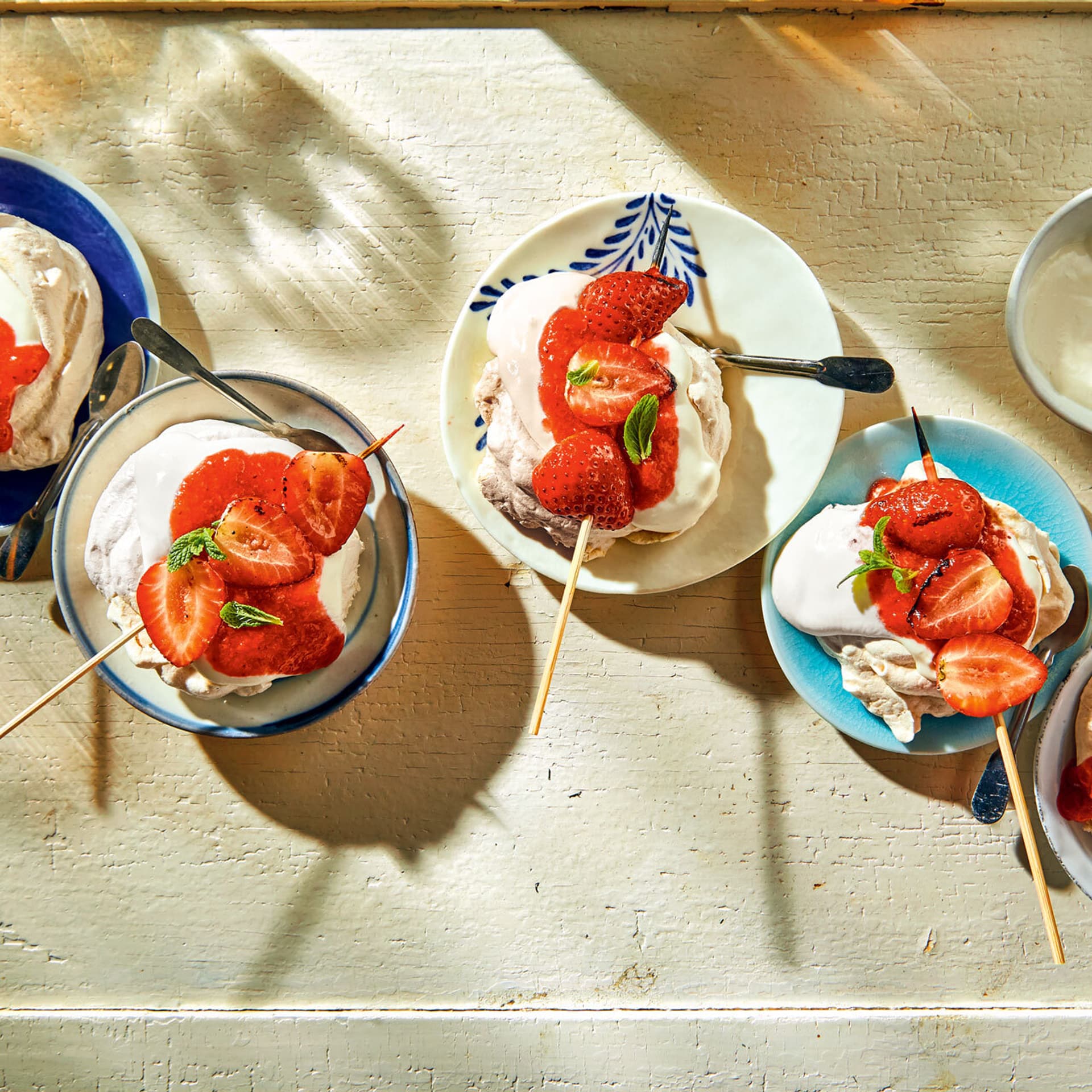 Mini-Baisers mit Grill-Erdbeeren in kleinen Schälchen.