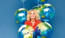 Susanne Fröhlich umgeben von Luftballons, die wie Erdkugeln aussehen