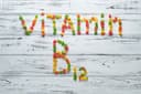 Vitamin B12 in bunter Schrift auf Holzboden