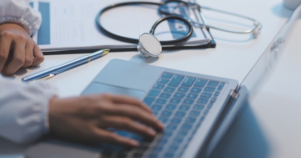 A healthcare professional reviews information on a laptop