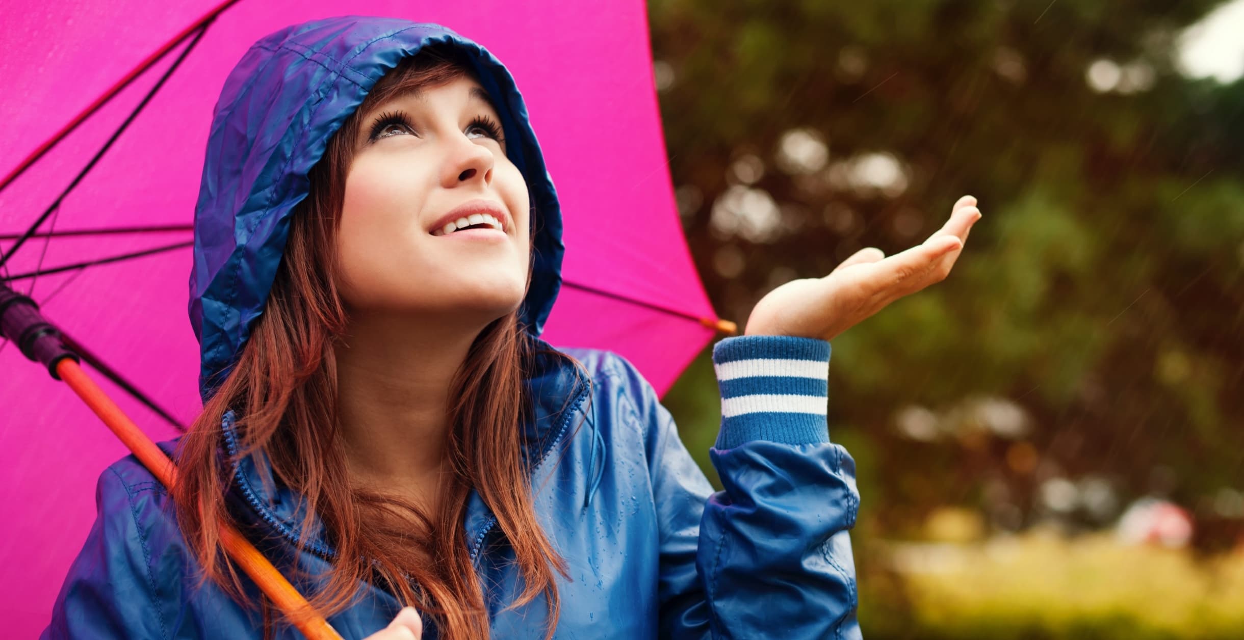 Woman raincoat with umbrella checking rain