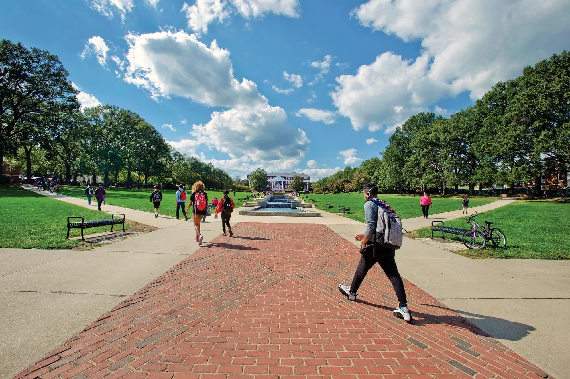 Students walking down a brick and concrete pathway on the UMD campus