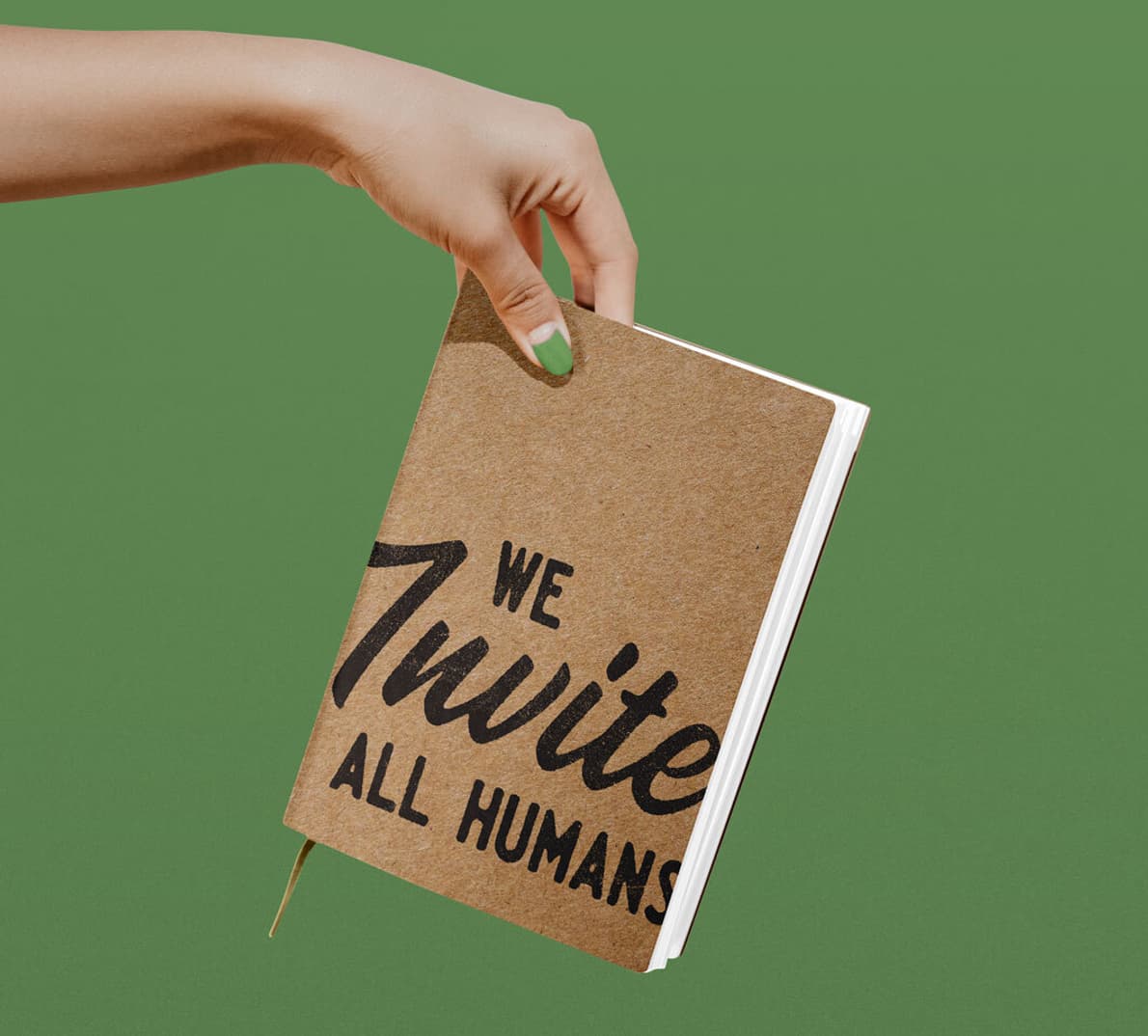 A hand holding a notebook that has a graphic that reads "We Invite All Humans"